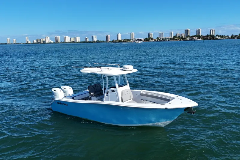 The Image of 2022 Sea Pro 259 Center Console boat on blue water with city skyline backdrop. - 0