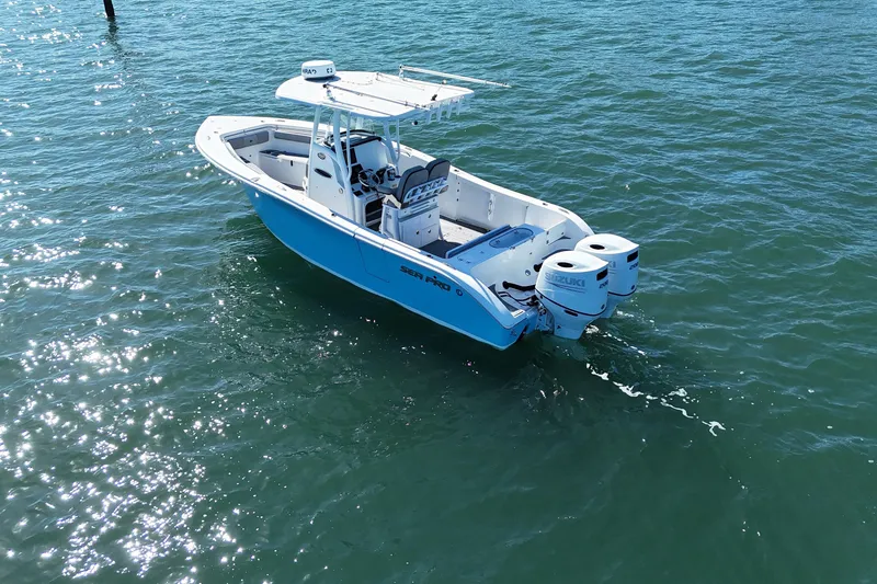 Slide: The Image of 2022 Sea Pro 259 Center Console boat on clear blue water, featuring dual Suzuki engines. - 11