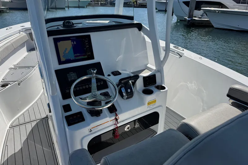 Slide: The Image of 2022 Sea Pro 259 Center Console boat interior with steering wheel and navigation display. - 12