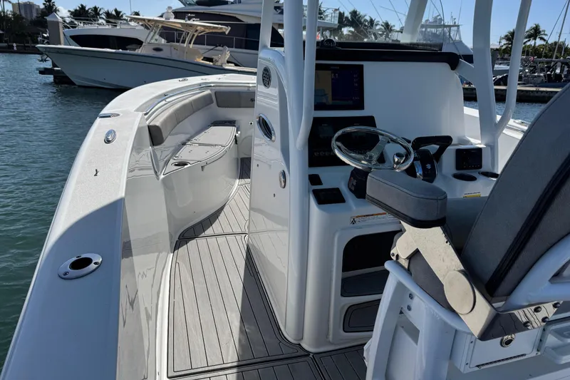 Slide: The Image of 2022 Sea Pro 259 Center Console boat interior with helm and seating, docked in marina. - 18