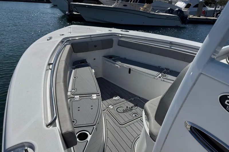 Slide: The Image of 2022 Sea Pro 259 Center Console boat interior with seating and storage, docked at marina. - 22
