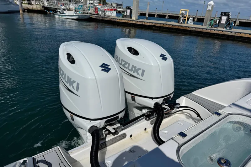 Slide: The Image of Twin Suzuki outboard engines on a 2022 Sea Pro 259 Center Console boat at a marina. - 32