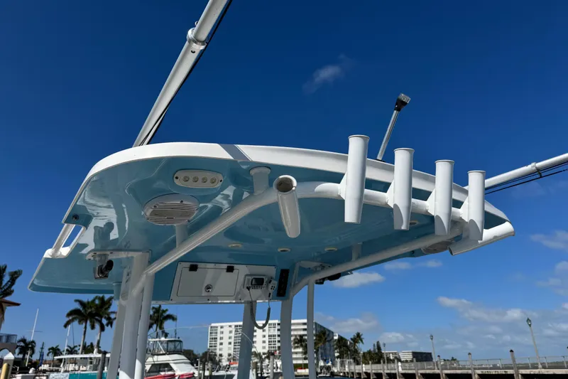 Slide: The Image of 2022 Sea Pro 259 Center Console boat with rod holders, under a clear blue sky. - 36