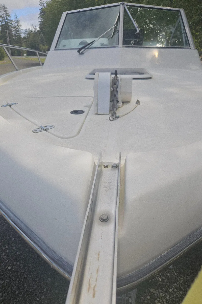 Slide: The Image of 1999 Pursuit 2460 Denali boat, front deck view with anchor chain, outdoors. - 14