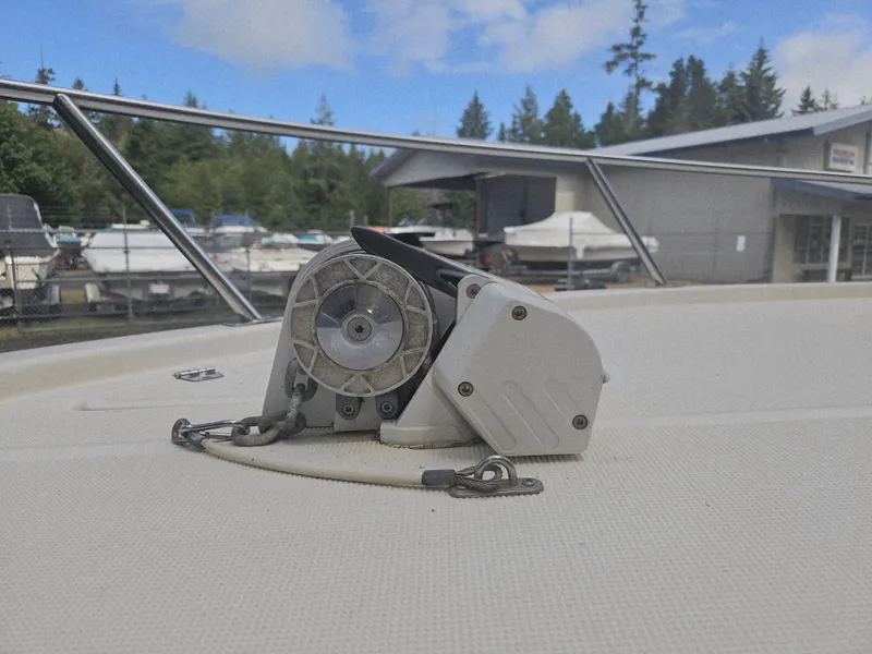 Slide: The Image of 1999 Pursuit 2460 Denali boat deck with anchor winch, marina background. - 15