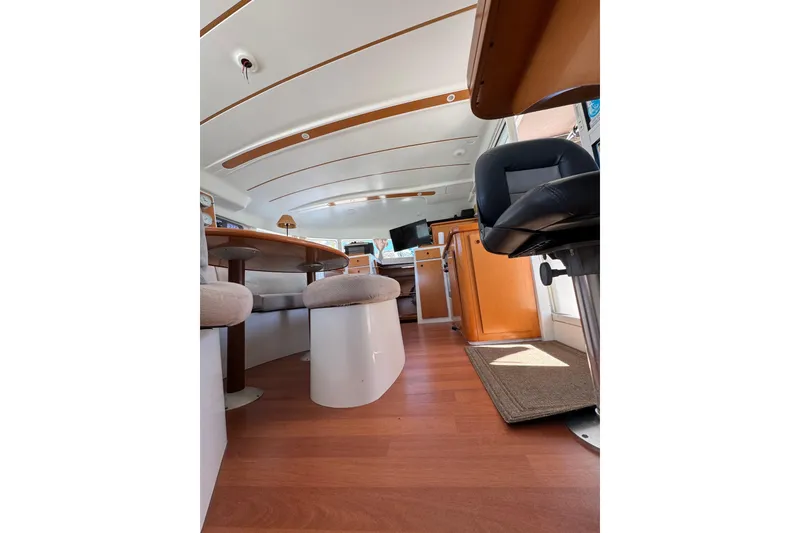 Slide: The Image of Interior of 2006 Lagoon 380 catamaran with modern seating and wooden flooring. - 12