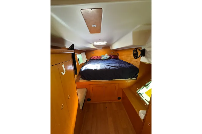 Slide: The Image of Cozy cabin interior of 2006 Lagoon 380 catamaran with bed and wooden furnishings. - 13