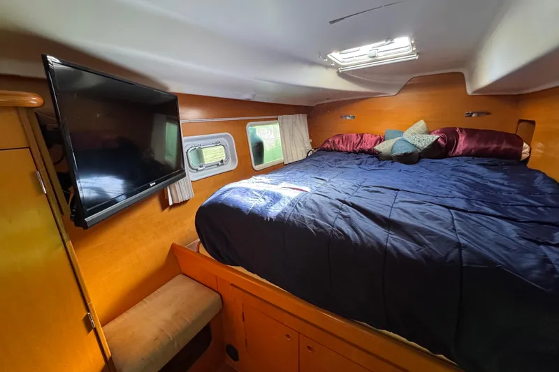 Slide: The Image of Interior of 2006 Lagoon 380 catamaran cabin with bed, TV, and porthole windows. - 14