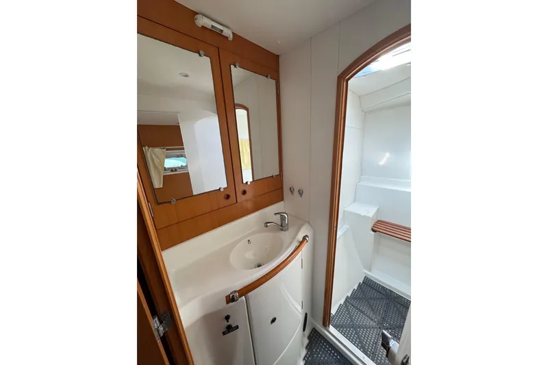 Slide: The Image of Bathroom interior of 2006 Lagoon 380 catamaran with sink, mirror, and shower area. - 18
