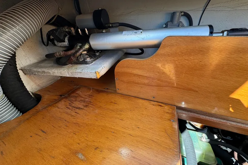 Slide: The Image of Engine compartment of a 2006 Lagoon 380 catamaran, featuring wooden paneling and mechanical components. - 24