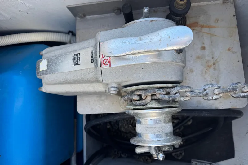 Slide: The Image of Anchor windlass on a 2006 Lagoon 380 catamaran with chain and blue tank. - 25