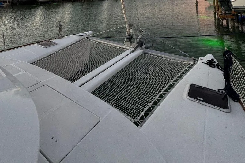 Slide: The Image of 2006 Lagoon 380 catamaran with netting, docked at a marina. - 29