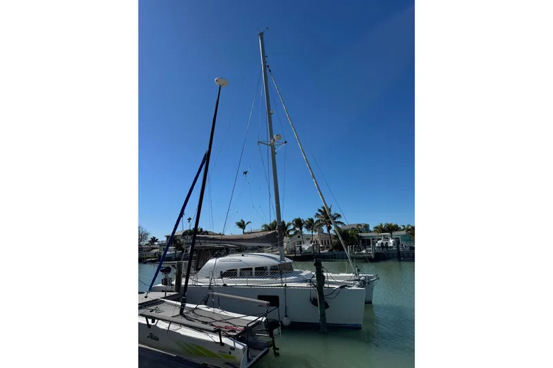 Slide: The Image of 2006 Lagoon 380 catamaran docked in sunny marina with clear blue sky. - 5