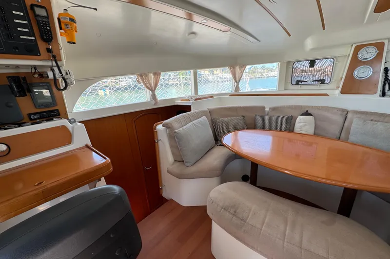Slide: The Image of Interior of 2006 Lagoon 380 catamaran with cozy seating and navigation equipment. - 7