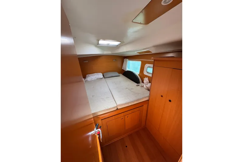 Slide: The Image of Cozy cabin interior of 2006 Lagoon 380 catamaran with bed and wooden storage. - 8