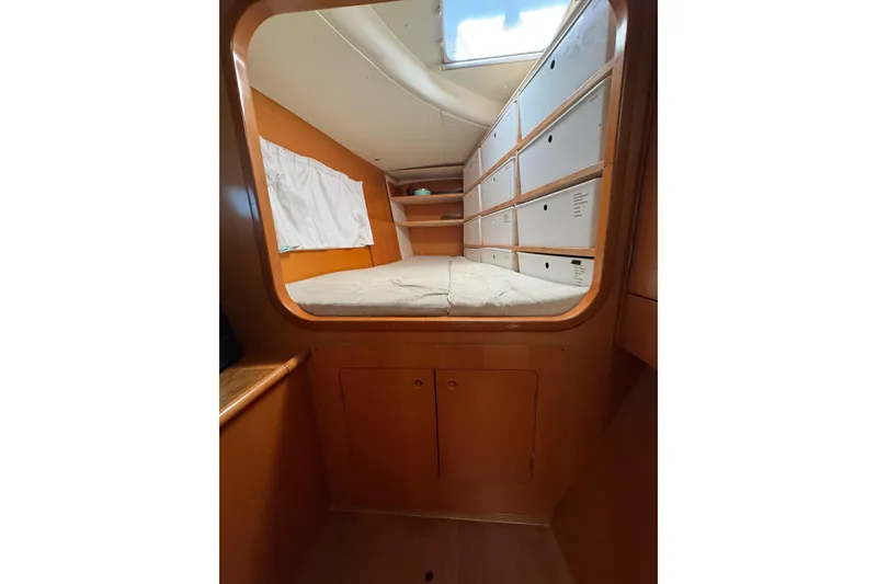 Slide: The Image of Interior cabin of 2006 Lagoon 380 catamaran with bed and storage compartments. - 9