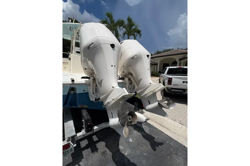 Slide: The Image of 2018 Cobia 301 Center Console with dual outboard engines, parked on a driveway. - 14