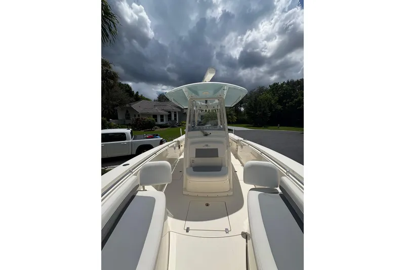 Slide: The Image of 2018 Cobia 301 Center Console boat under cloudy sky, parked in residential area. - 15