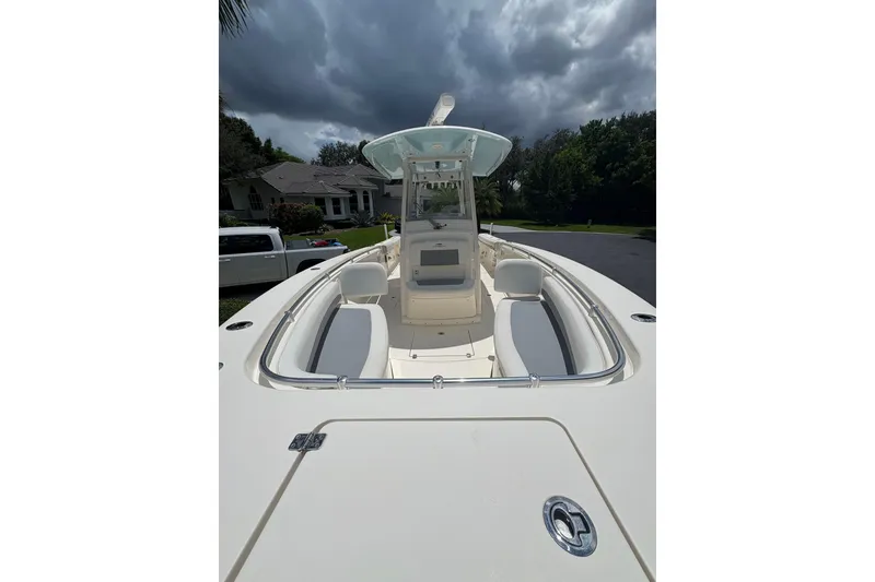 Slide: The Image of 2018 Cobia 301 Center Console boat with sleek design under cloudy sky. - 17