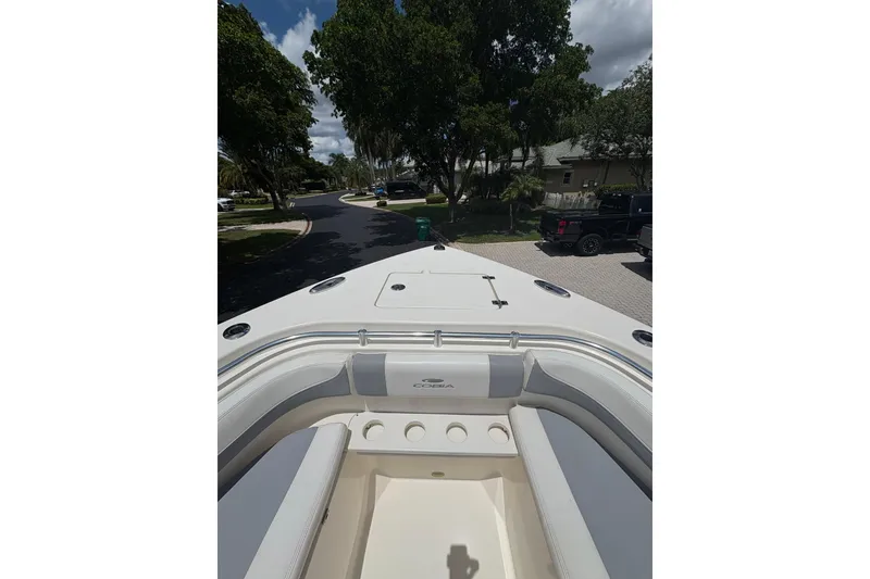 Slide: The Image of 2018 Cobia 301 Center Console boat parked in a residential driveway. - 23