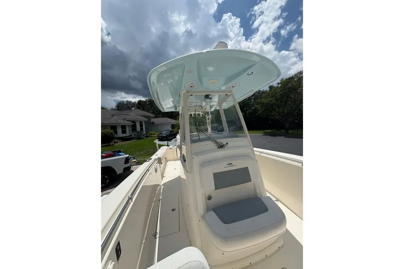 Slide: The Image of 2018 Cobia 301 Center Console boat under cloudy sky, parked in residential area. - 25