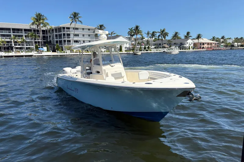 Slide: The Image of 2018 Cobia 301 Center Console boat on water near waterfront homes. - 6