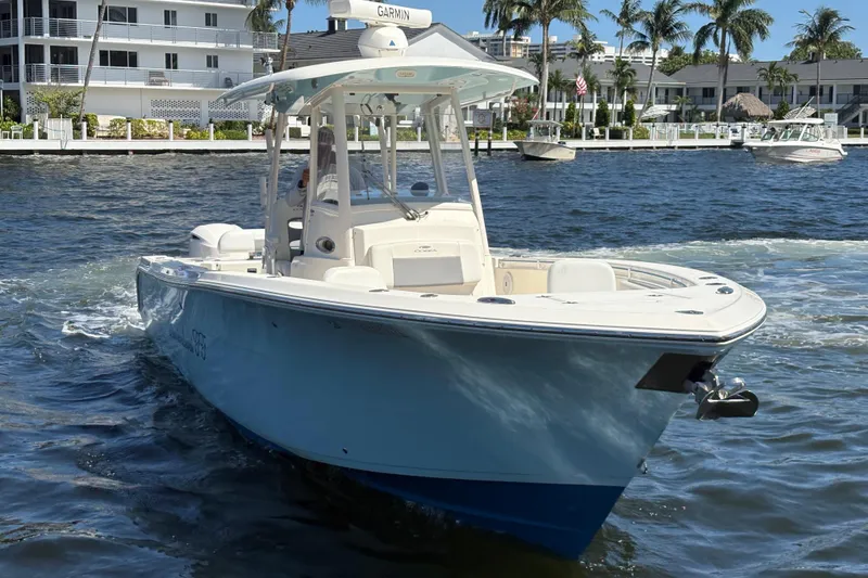 Slide: The Image of 2018 Cobia 301 Center Console boat cruising on a sunny waterfront. - 7