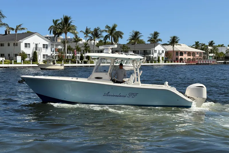 Slide: The Image of 2018 Cobia 301 Center Console boat cruising on a sunny waterfront. - 9