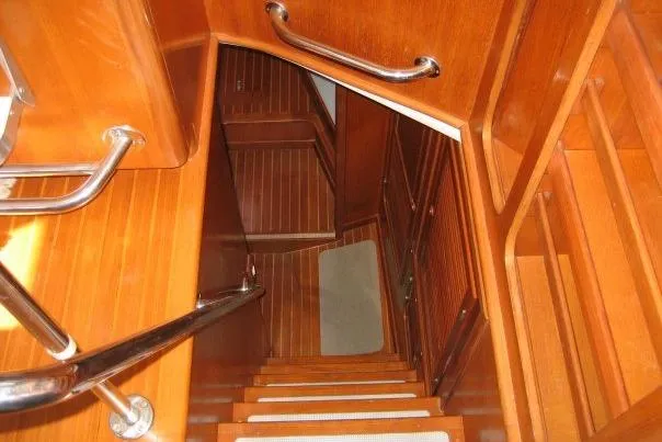 Slide: The Image of Staircase inside 1990 Nordhavn 46 yacht, featuring wooden steps and metal handrails. - 10