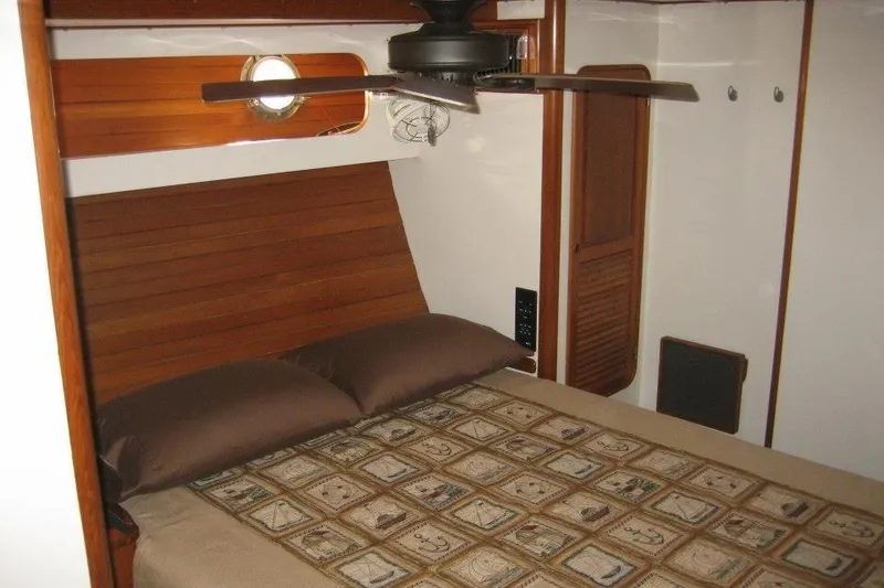 Slide: The Image of Cozy cabin interior of 1990 Nordhavn 46 yacht with wooden accents and ceiling fan. - 13
