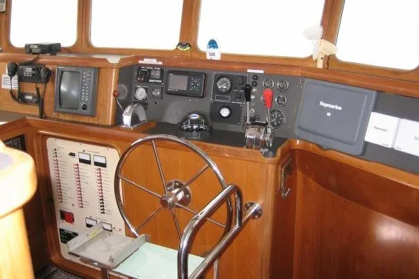 Slide: The Image of 1990 Nordhavn 46 yacht helm with navigation equipment and wooden steering wheel. - 6