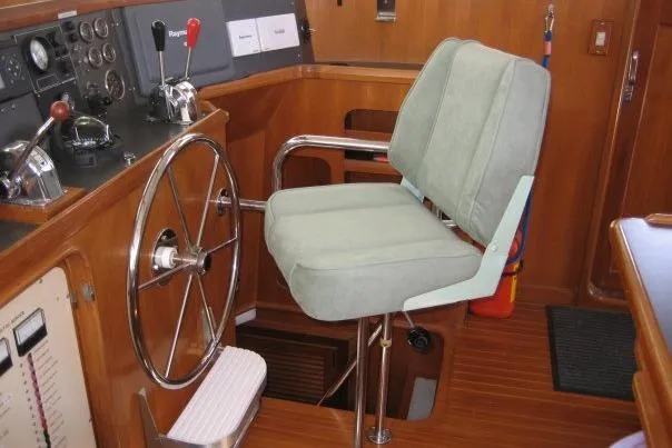 Slide: The Image of Helm station of 1990 Nordhavn 46 yacht with steering wheel and cushioned chair. - 7