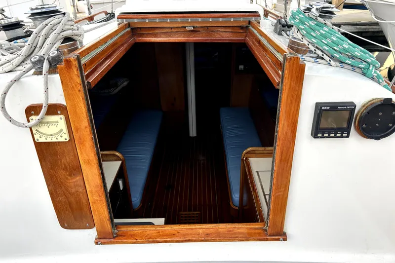 Slide: The Image of 1969 Hinckley 38 sailboat cabin entrance with wooden trim and nautical instruments. - 18