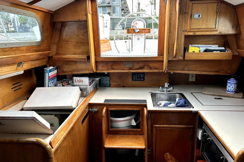Slide: The Image of Interior of a 1969 Hinckley 38 sailboat with wooden cabinetry and compact kitchen area. - 3