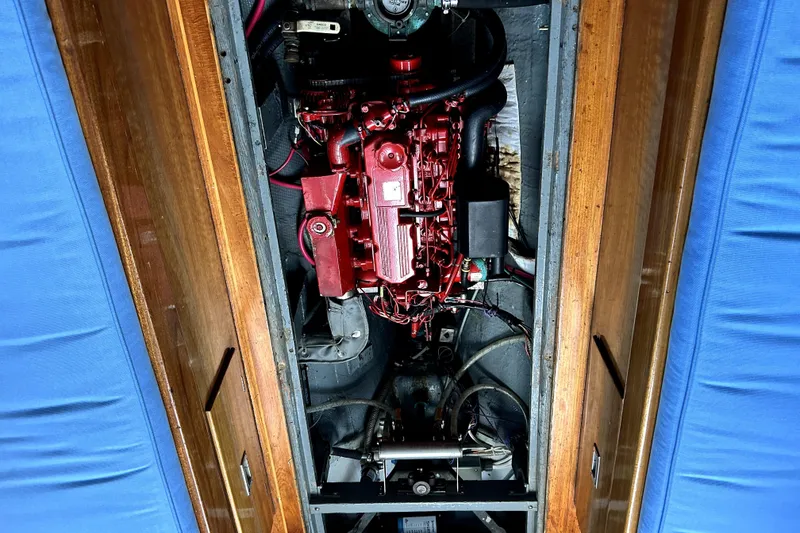 Slide: The Image of Engine compartment of a 1969 Hinckley 38 sailboat, featuring a red engine and wooden paneling. - 32