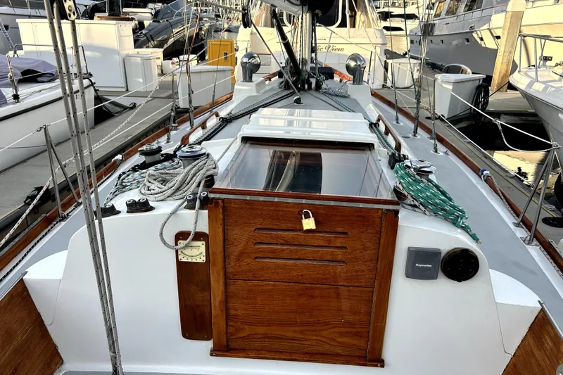 Slide: The Image of 1969 Hinckley 38 sailboat deck with ropes and wooden hatch at marina. - 8