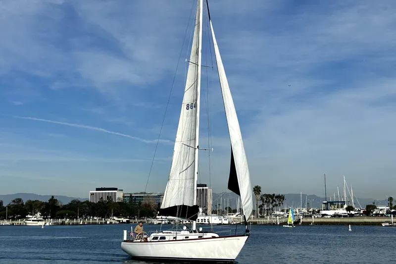 Slide: The Image of 1969 Hinckley 38 sailboat on calm water with cityscape background. - 13