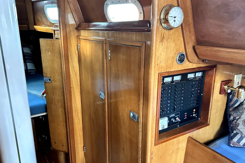 Slide: The Image of Interior of a 1969 Hinckley 38 sailboat featuring wooden cabinetry and control panel. - 22