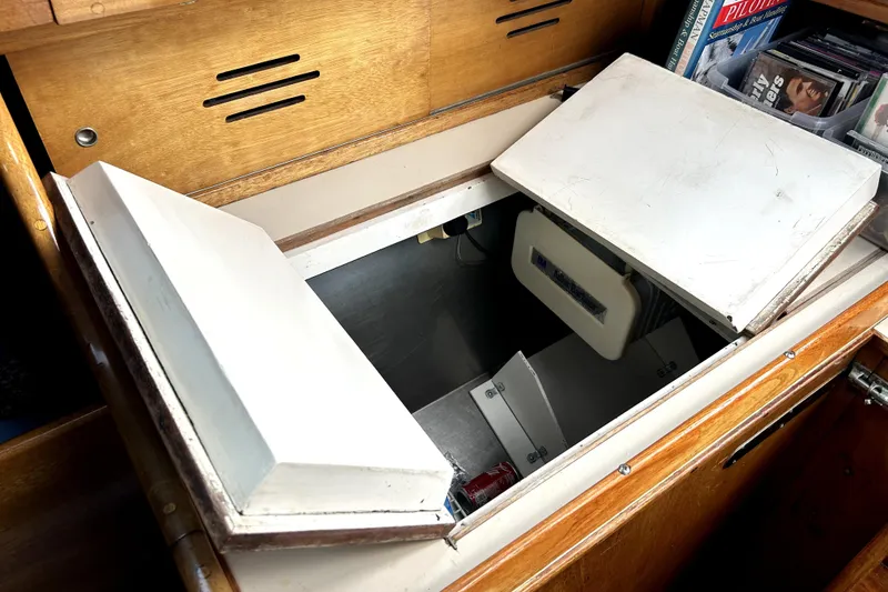 Slide: The Image of Open storage compartment on a 1969 Hinckley 38 boat, featuring wooden cabinetry and interior space. - 25