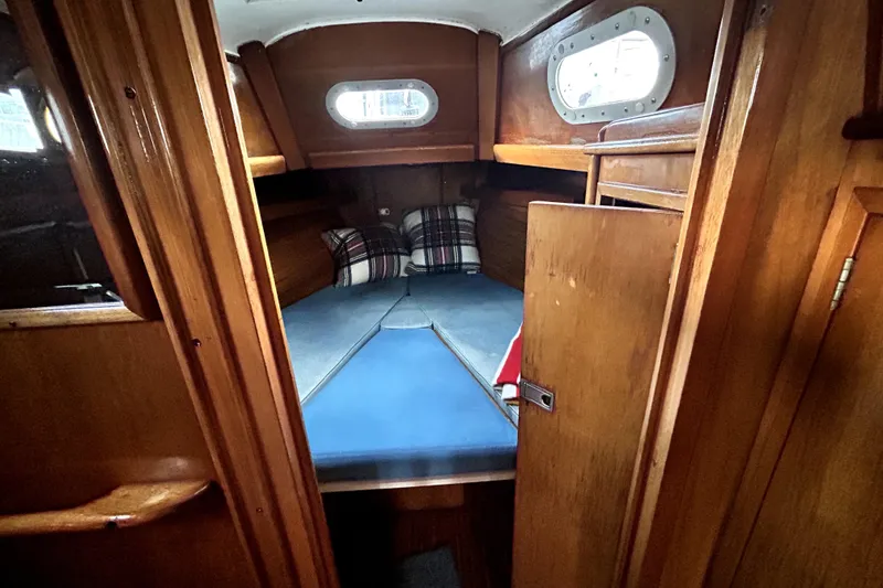 Slide: The Image of Cabin interior of a 1969 Hinckley 38 sailboat with wooden finish and cozy bedding. - 28