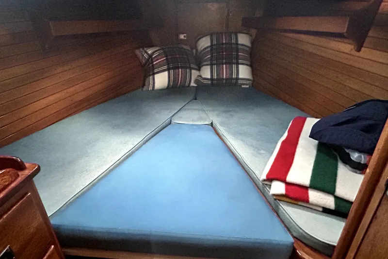 Slide: The Image of Cozy cabin interior of a 1969 Hinckley 38 sailboat with plaid pillows and striped blanket. - 29