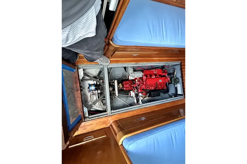 Slide: The Image of Engine compartment of a 1969 Hinckley 38 sailboat, featuring a red engine and wooden interior. - 33