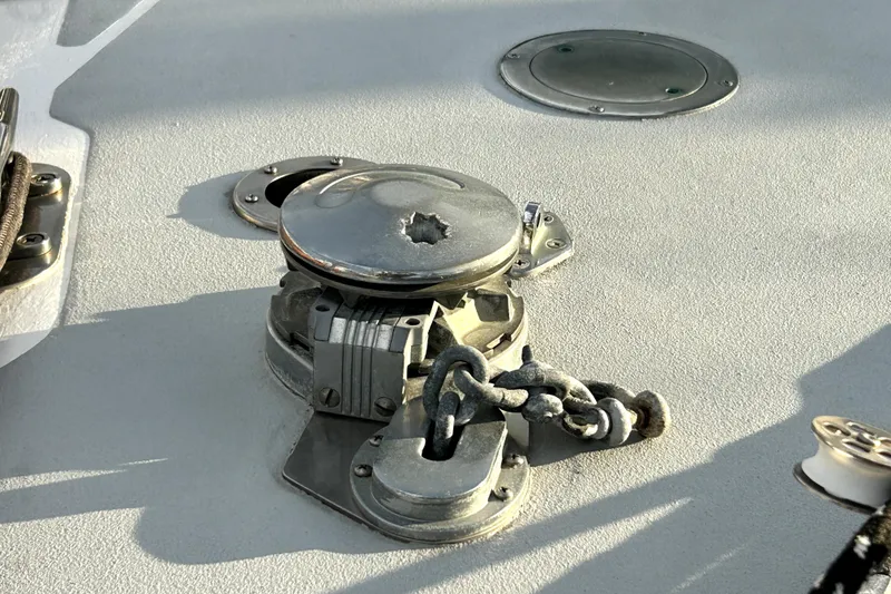 Slide: The Image of Deck equipment on a 1969 Hinckley 38 sailboat, featuring a metal winch and chain. - 7