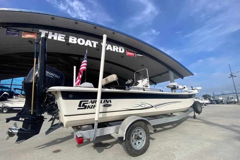 Slide: The Image of 2015 Carolina Skiff 20 JVX CC boat on trailer at dealership, clear sky background. - 2