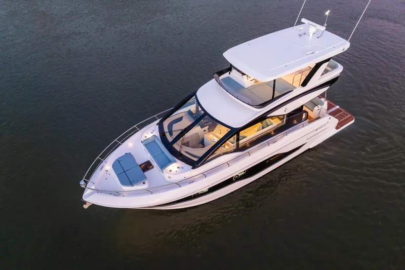 Slide: The Image of 2026 Cruisers 50 Fly yacht on calm water, showcasing sleek design and luxury features. - 10