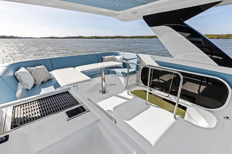 Slide: The Image of Luxurious 2026 Cruisers 50 Fly yacht deck with seating, table, and grill overlooking water. - 19
