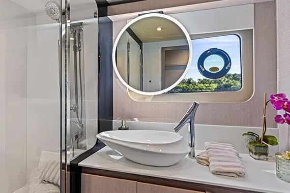 Slide: The Image of Luxurious bathroom in 2026 Cruisers 50 Fly yacht with modern fixtures and scenic window view. - 32
