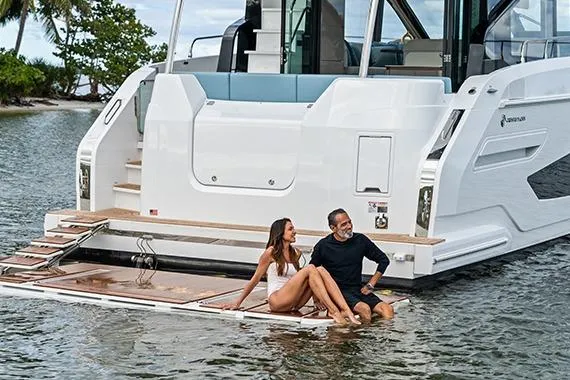 Slide: The Image of Couple relaxing on 2026 Cruisers 50 Fly yacht platform in serene waters. - 22