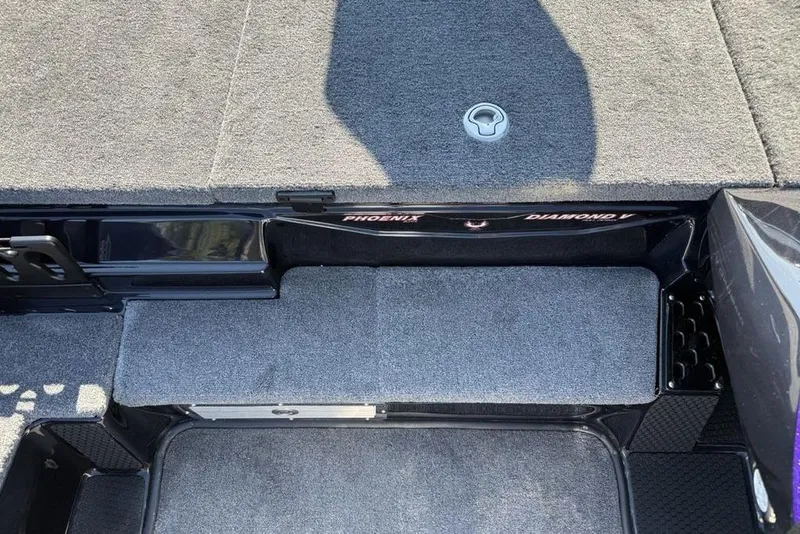 Slide: The Image of Interior view of 2026 Phoenix 920 Elite X boat, featuring carpeted flooring and storage compartments. - 10