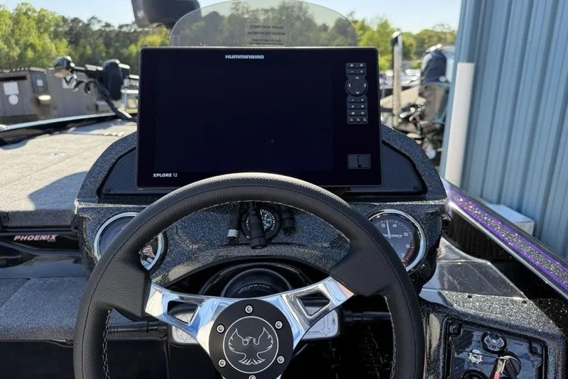 Slide: The Image of Steering wheel and dashboard of 2026 Phoenix 920 Elite X boat with navigation display. - 16